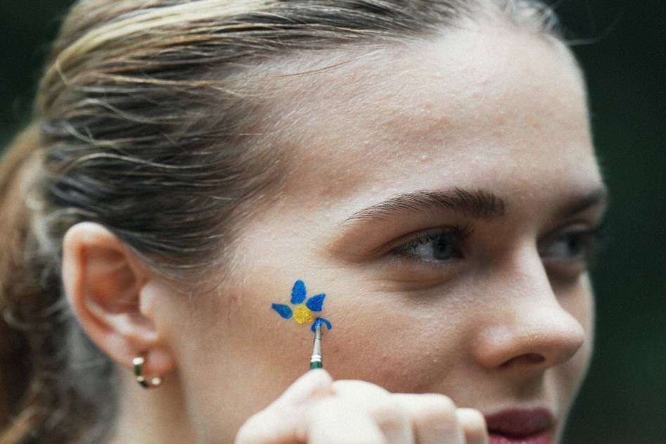 Editorial makeup artist creating a dramatic look with vibrant eyeshadow and bold contouring