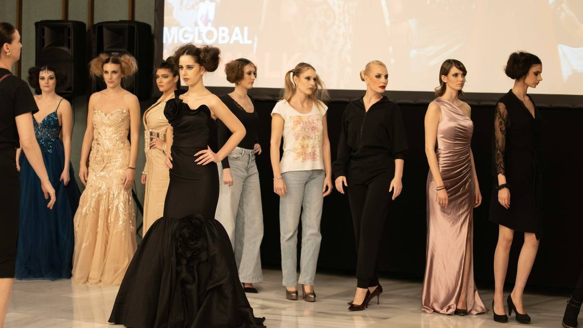 Close-up of fierce catwalk beauty showing asymmetrical eye detail and matte lip under runway lighting