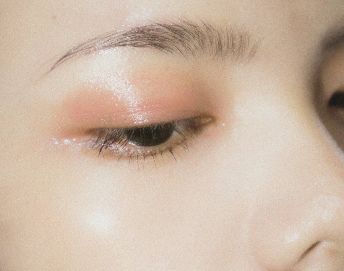 Model wearing bold abstract makeup ideas with geometric metallic streaks and negative space design
