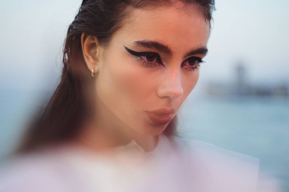 Close-up of experimental bold makeup textures using layered wax and pigment on model's temple