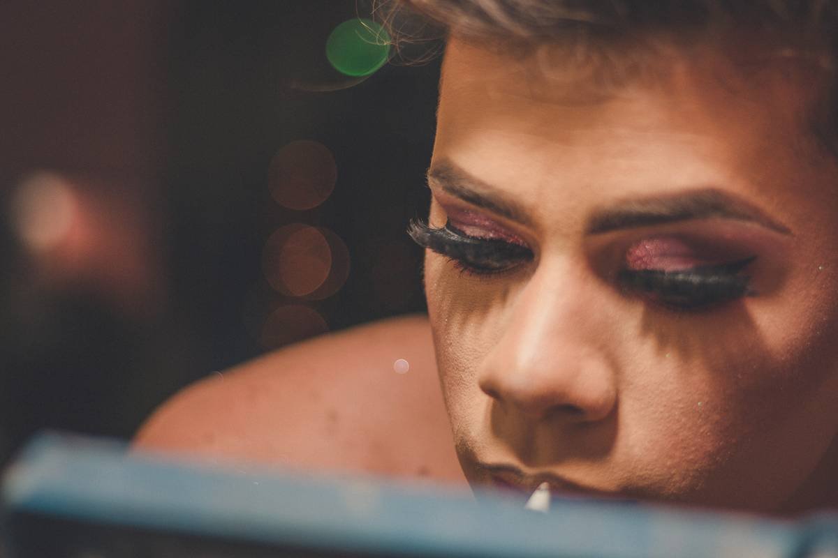 Avant-garde model showcasing bold makeup textures with cracked metallic finish on cheekbones